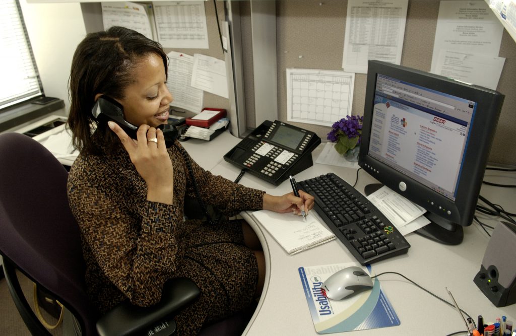African American health information staffer answering a phone inquiry