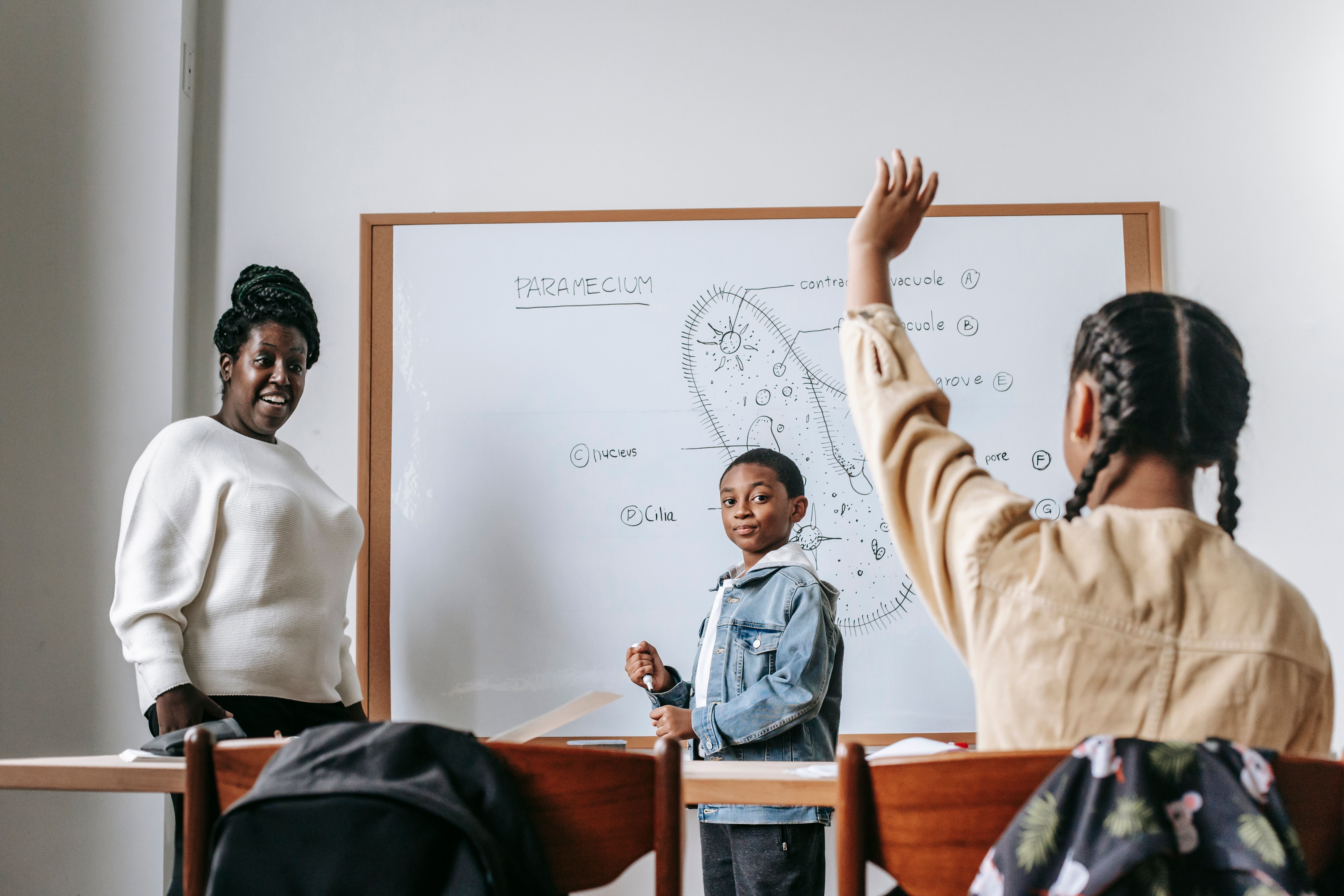 A teacher helping a student one on one at a classroom whiteboard