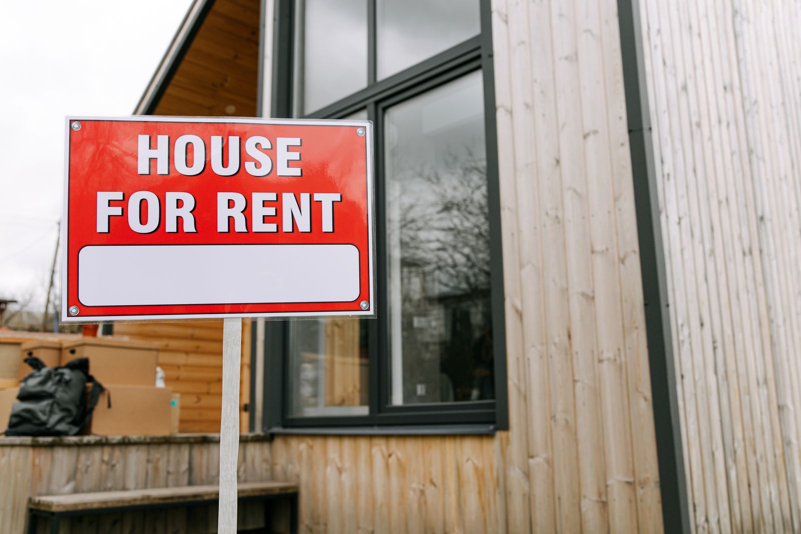 A house for rent sign posted outside a property