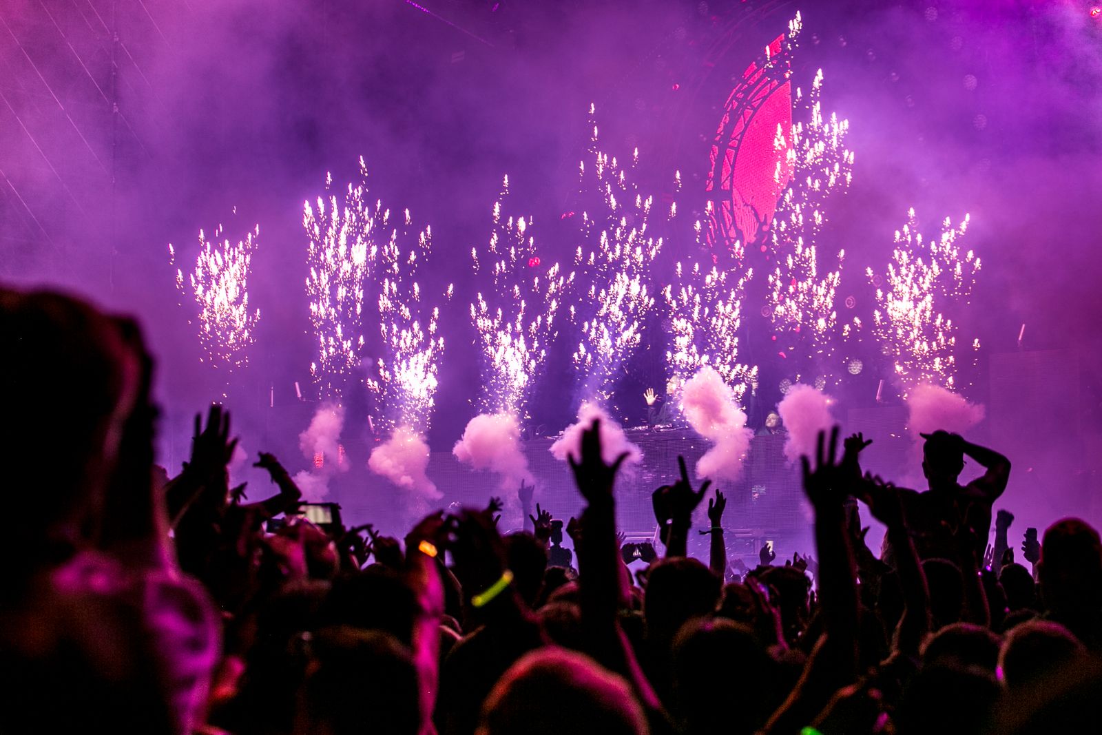 Crowd with arms raised at an outdoor summer music festival