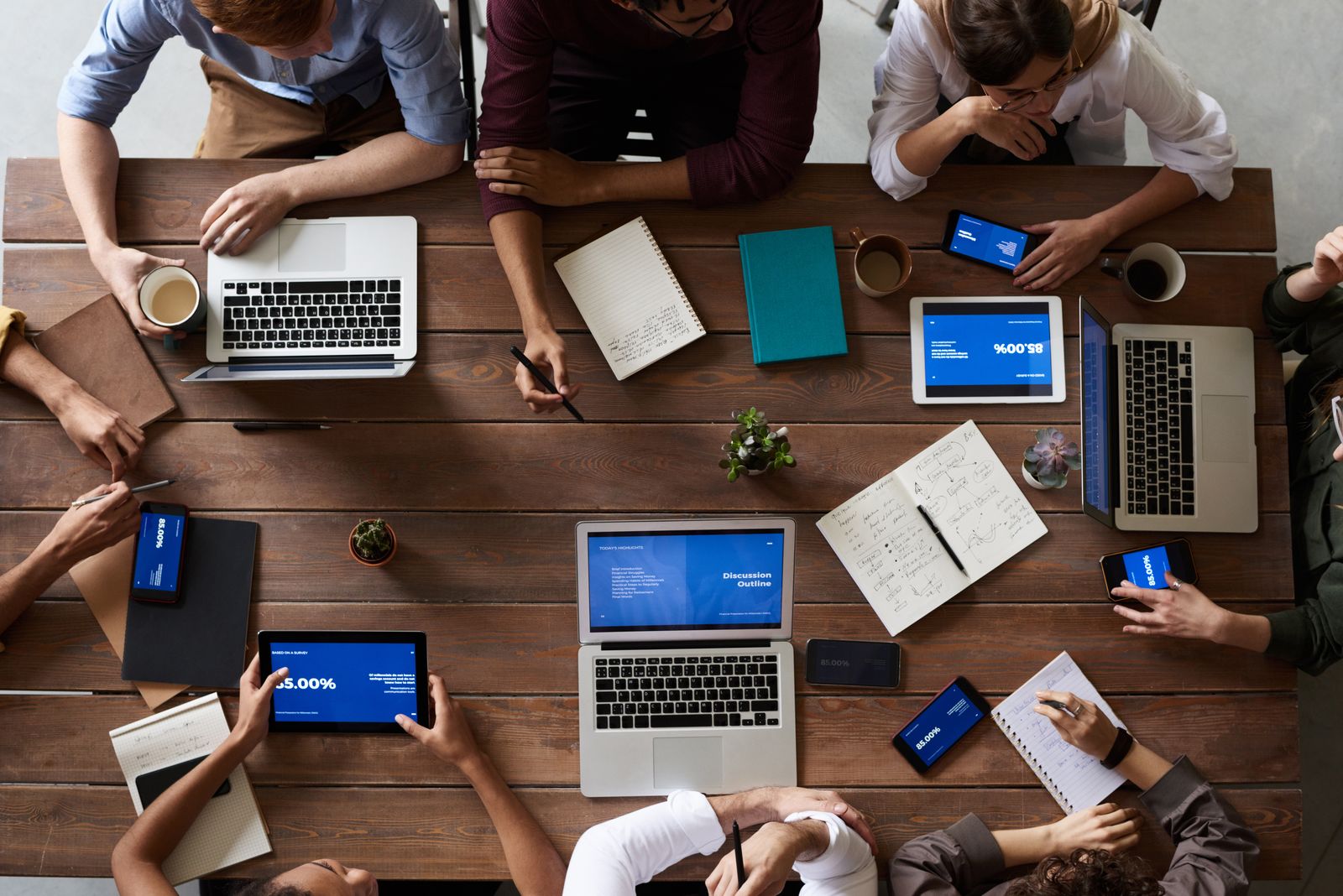 An overhead view of a diverse team in a business meeting using laptops and tablets