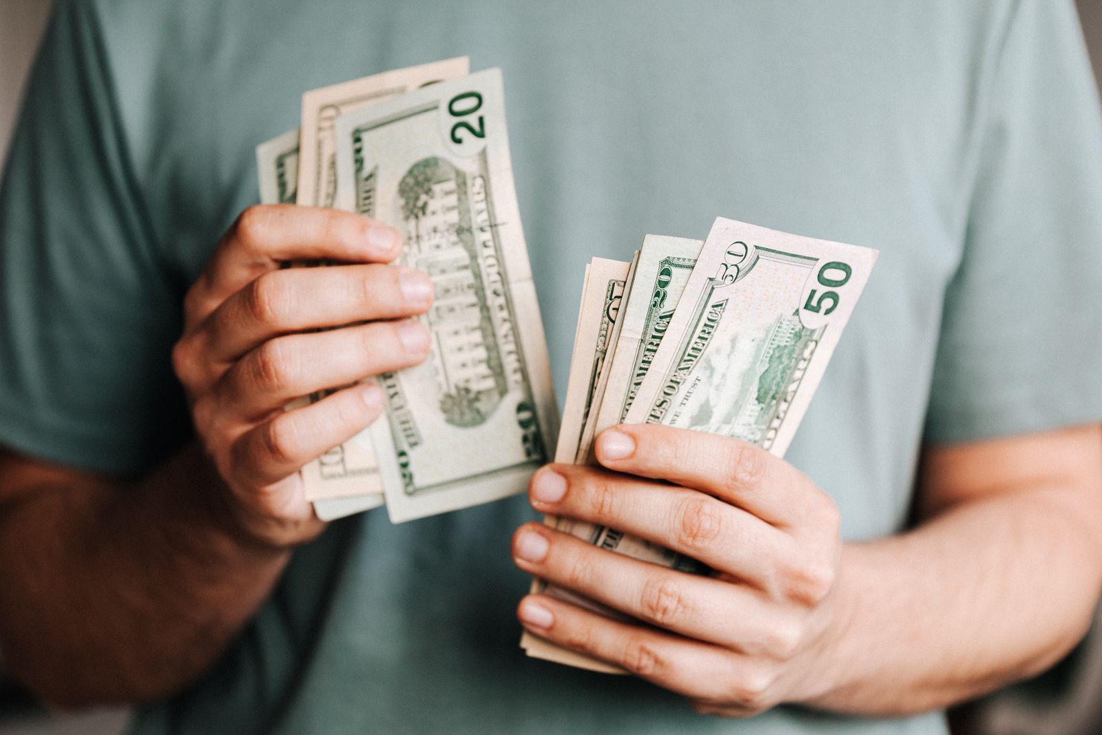 A person counting dollar banknotes by hand