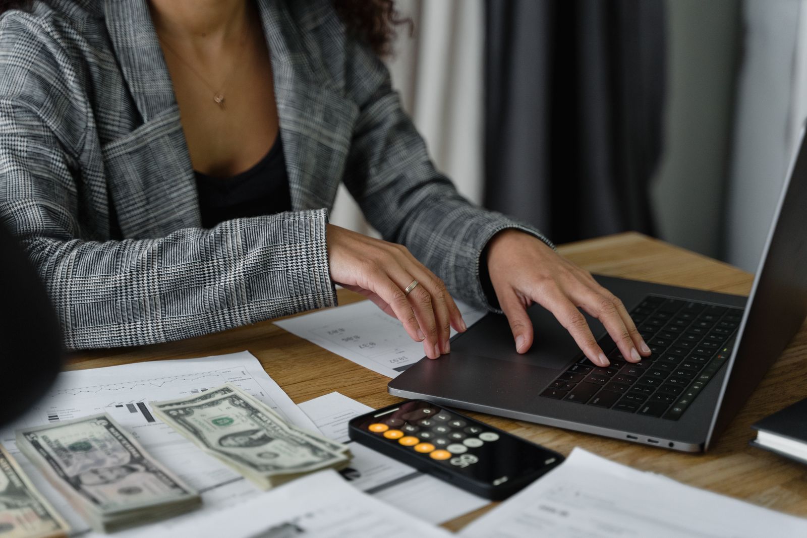 A businesswoman working on finance management with cash and a calculator