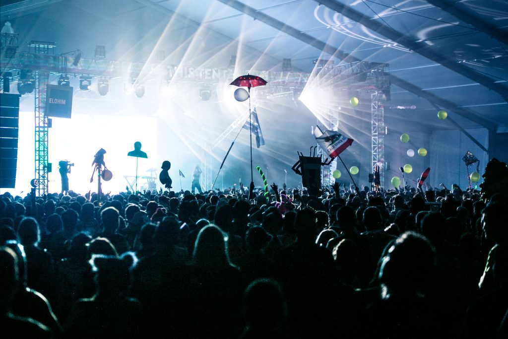 A performer lit by stage lights in front of a live audience at an awards-style show