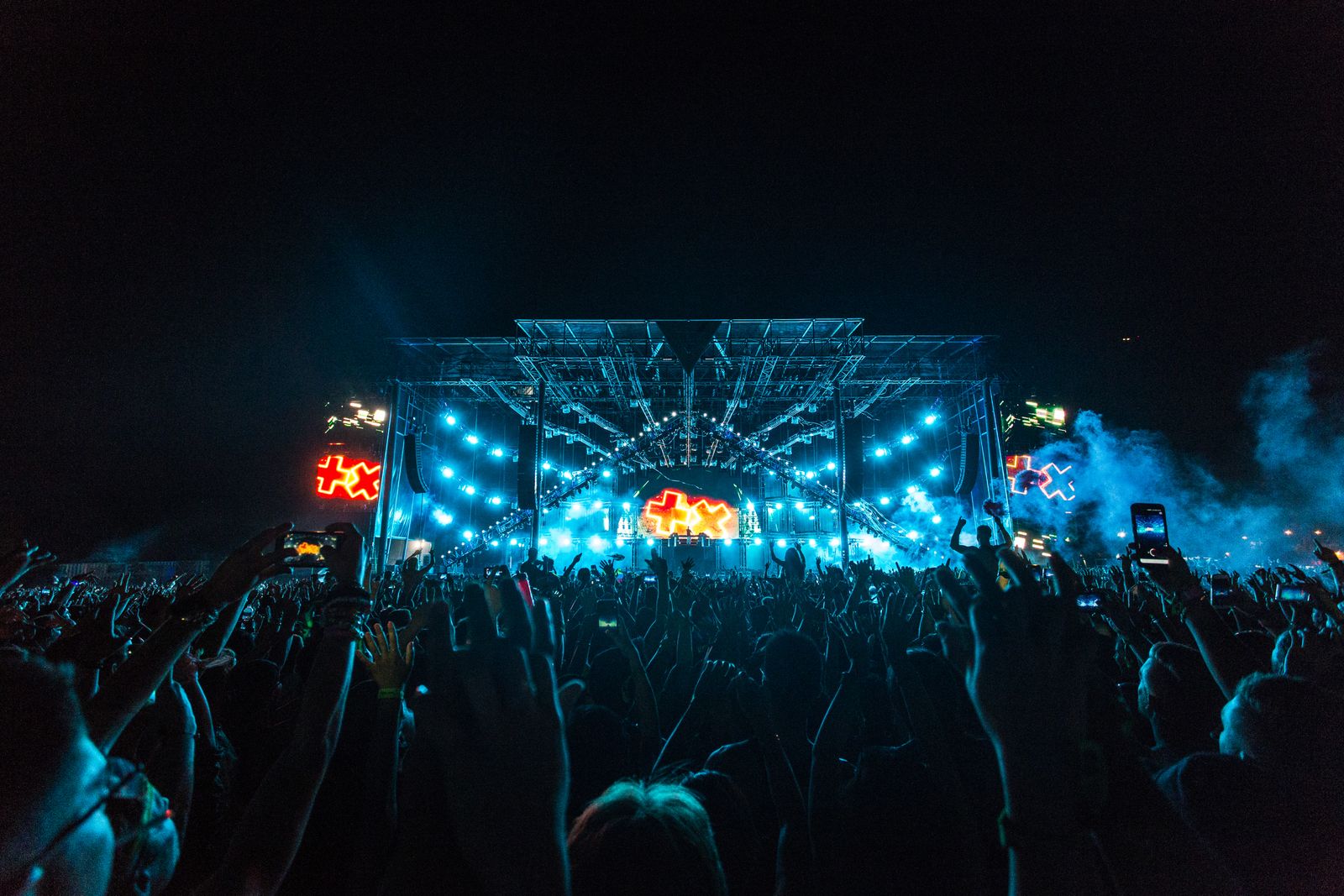 Concert crowd in front of a lit stage at night
