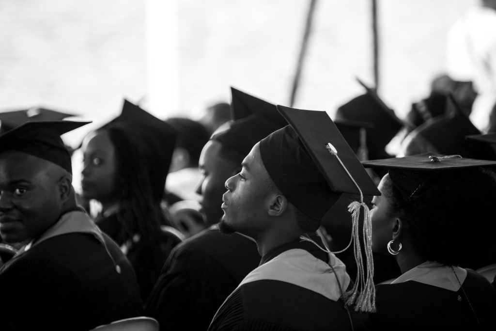 Black graduates in caps and gowns at commencement