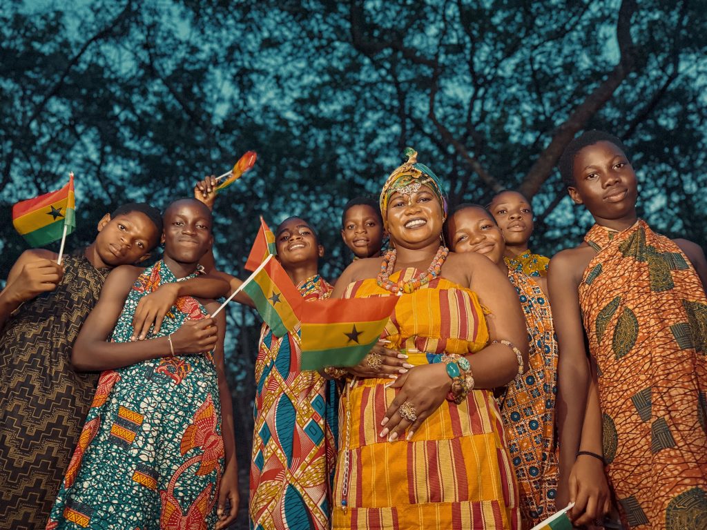 People in traditional kente cloth celebrating in Ghana, a top ancestry travel destination