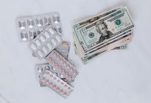 Medical Debt Can Hit Your Credit Report Again in 2026: How to Protect Your Score Medication packaging resting on a stack of U.S. dollar bills, illustrating medical costs.