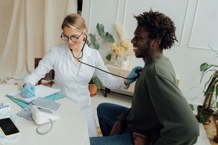 Doctor checking patient heart rate with stethoscope during checkup
