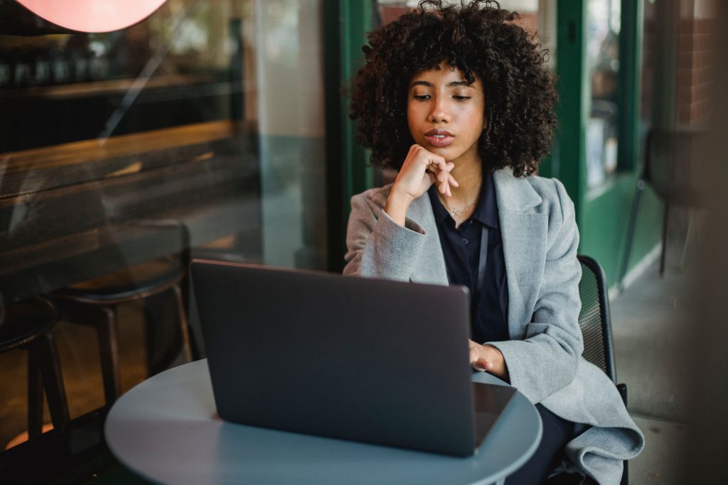A focused Black woman small-business owner working on a laptop