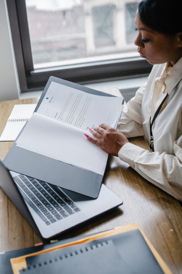A Black entrepreneur reviewing business documents at a desk