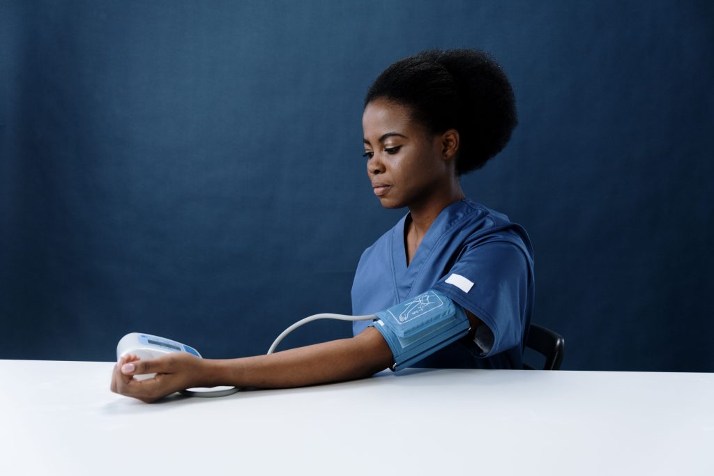 Black nurse with a blood pressure cuff