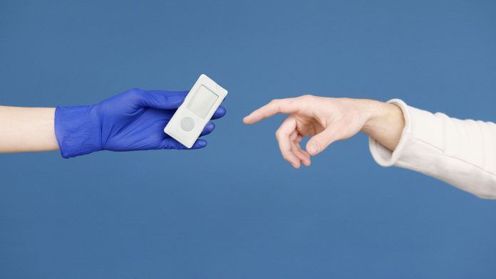 Medical professional handing patient a blood glucose meter