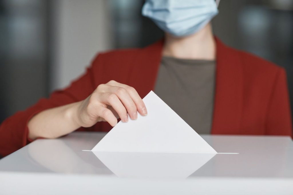 Person casting a ballot into a ballot box