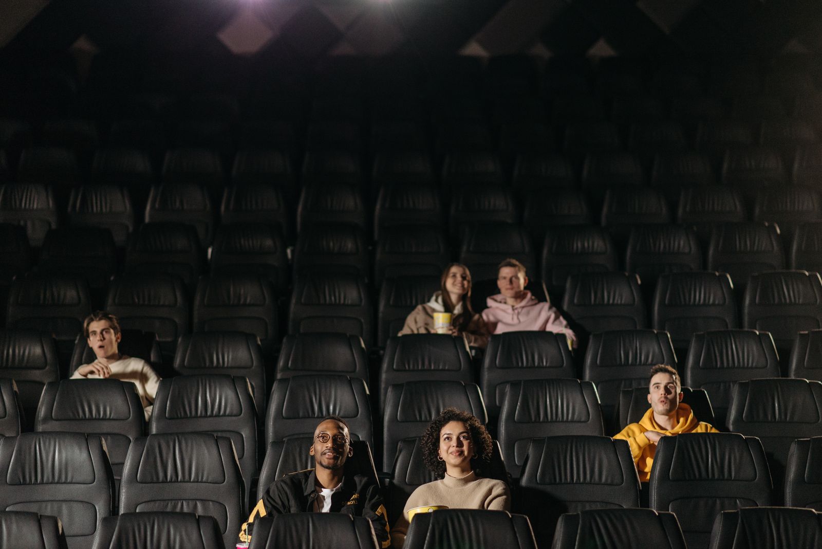 Audience members watching a film together in a movie theater