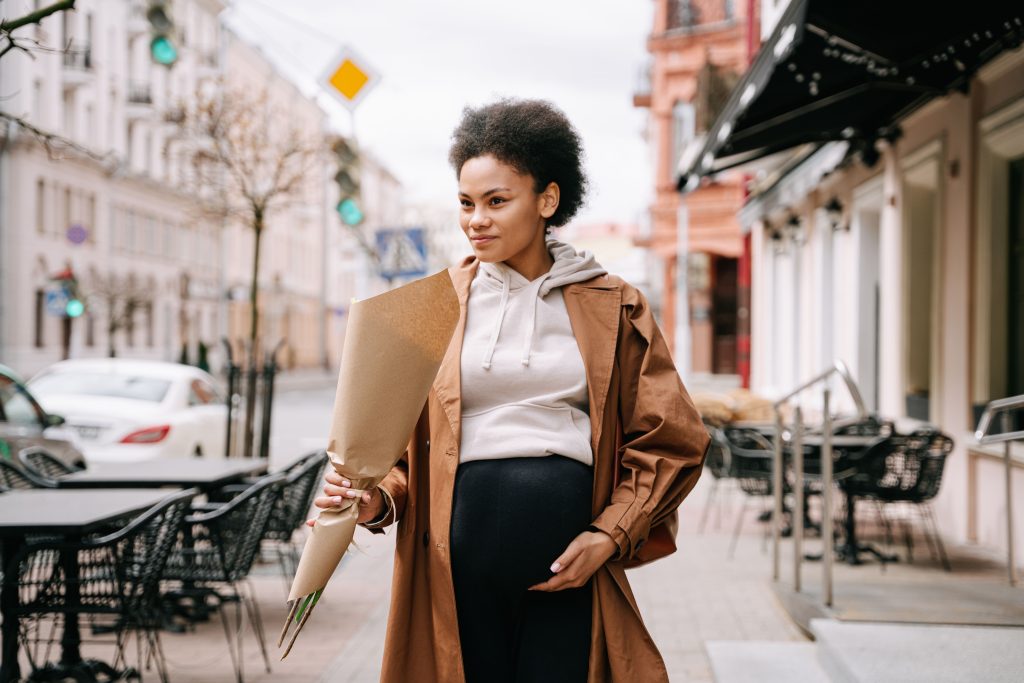 A pregnant Black woman cradling her belly, illustrating the stakes of Medicaid cuts for Black maternal health