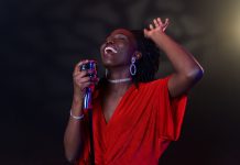 Tyla’s A*Pop: What to Expect From the Sophomore Album Landing July 24 A Black woman singer performing on stage with a microphone under warm lighting