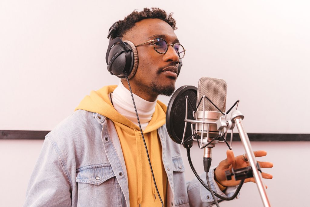 Black music artist recording in a studio