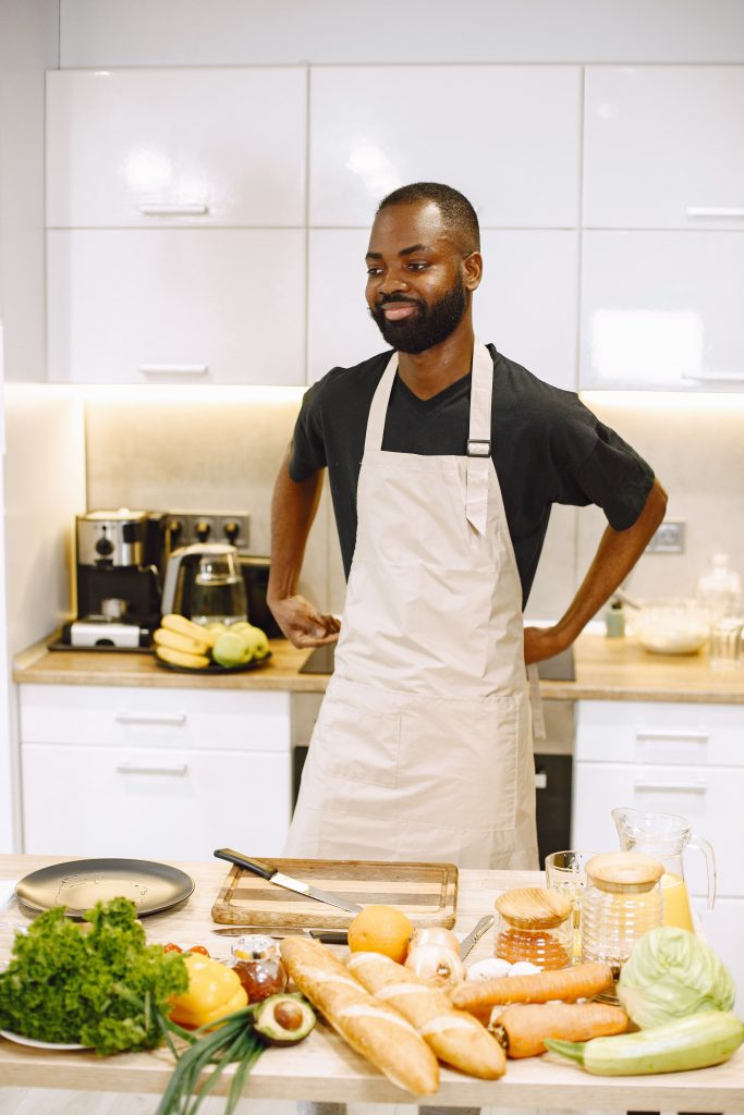 A Black chef preparing fresh ingredients in a professional kitchen