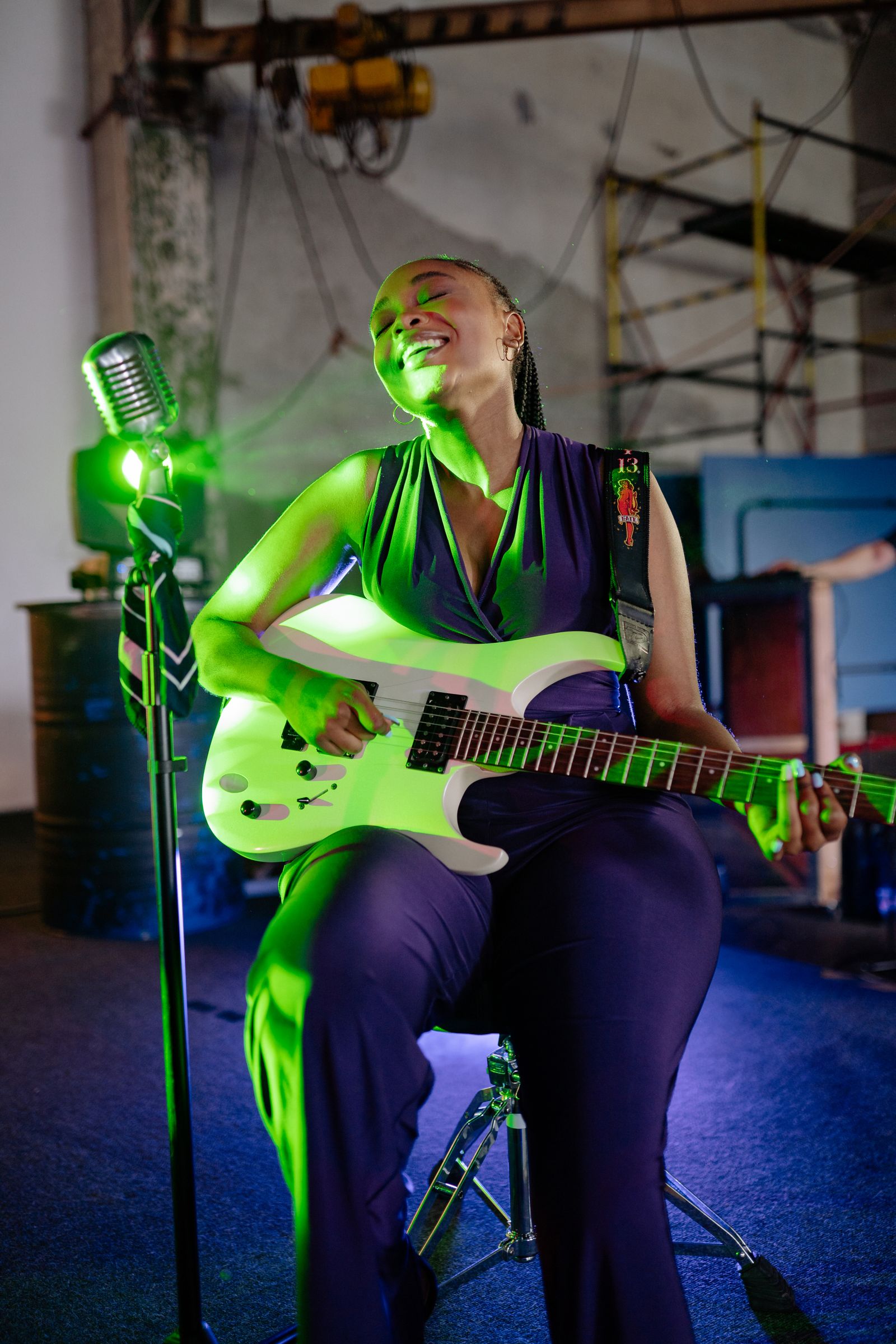 A performer singing into a microphone during a live concert