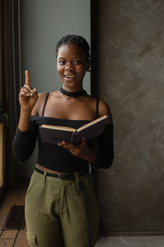 A Black woman reading a book, representing a fall 2026 reading list of Black authors