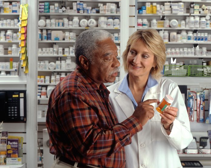 prep-pharmacist African American man consulting with a pharmacist about his prescription