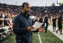 Black NFL Head Coaches and GMs in 2026: Who Holds the Jobs Now A Black football head coach on the sideline wearing a headset and holding a play sheet at dusk